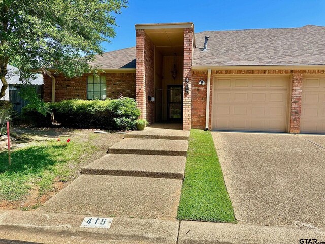415 Amberwood Cir, Tyler, TX 75701 - view of front facade with brick siding, driveway, a shingled roof, and an attached garage