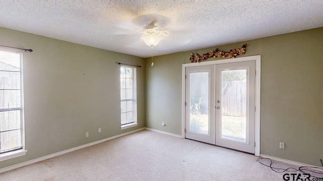 415 Amberwood Cir, Tyler, TX 75701 - carpeted spare room featuring french doors, ceiling fan, a textured ceiling, and baseboards