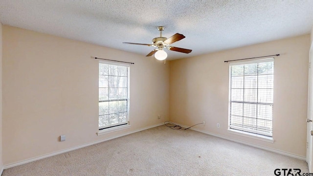 415 Amberwood Cir, Tyler, TX 75701 - spare room with plenty of natural light, carpet floors, a ceiling fan, a textured ceiling, and baseboards