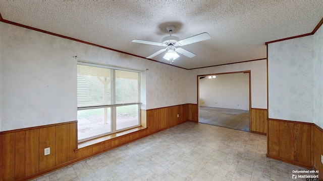 218 Lilly Ln, Bullard, TX 75757 - unfurnished room featuring a wainscoted wall, wood walls, a textured ceiling, light flooring, and ornamental molding