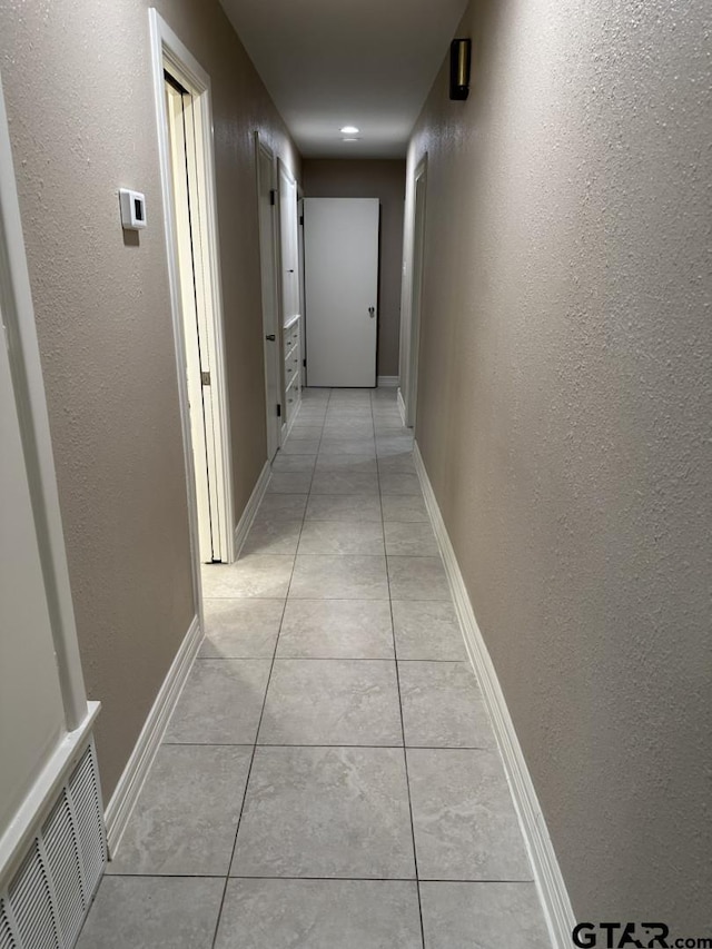 hall with light tile patterned floors