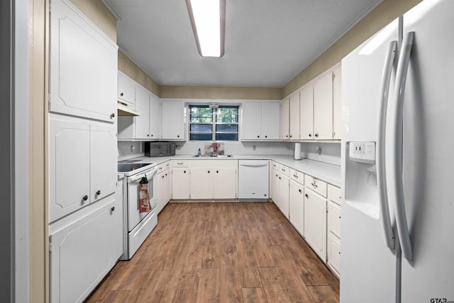 kitchen featuring white appliances, white cabinetry, dark wood-type flooring, and sink