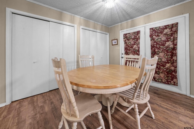 dining space with dark hardwood / wood-style flooring, ornamental molding, and a textured ceiling