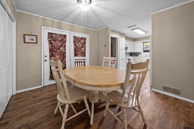 dining room featuring a textured ceiling, dark hardwood / wood-style flooring, and ornamental molding