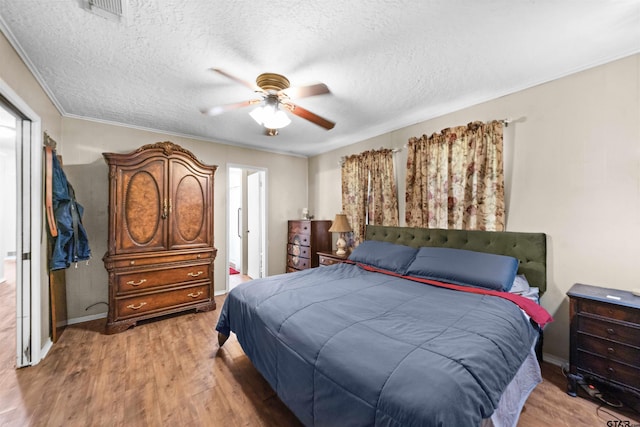 bedroom with ceiling fan, a textured ceiling, and hardwood / wood-style flooring