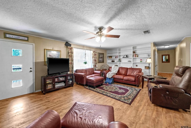 living room featuring hardwood / wood-style floors, a textured ceiling, built in features, and ceiling fan