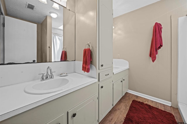 bathroom featuring vanity, wood-type flooring, and a textured ceiling