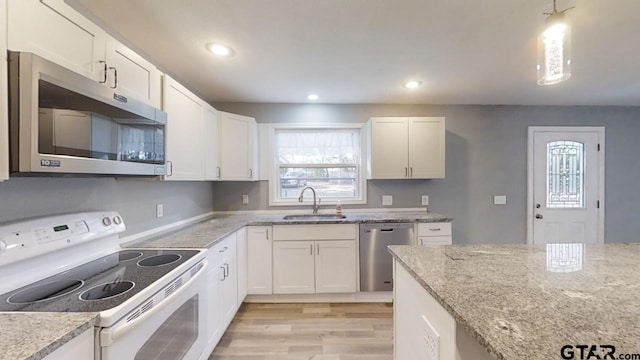 kitchen featuring white cabinets, appliances with stainless steel finishes, light hardwood / wood-style flooring, and sink