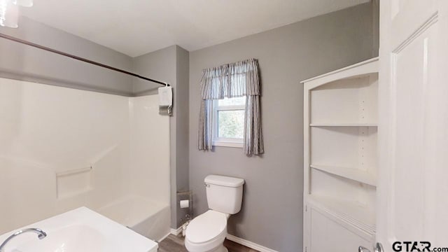 full bathroom with sink, wood-type flooring, bathtub / shower combination, and toilet