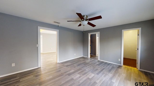 empty room with hardwood / wood-style floors and ceiling fan