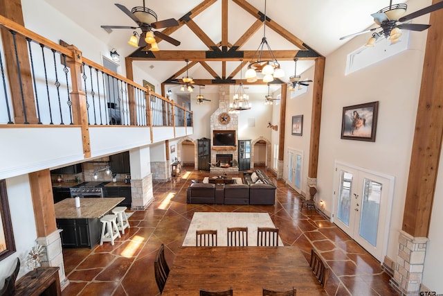 living room with beamed ceiling, a healthy amount of sunlight, a fireplace, and high vaulted ceiling