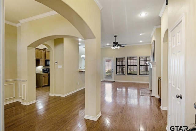 5609 Andover Dr, Tyler, TX 75707 - foyer entrance featuring dark wood-style flooring, a ceiling fan, crown molding, and arched walkways