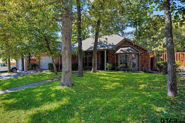 5609 Andover Dr, Tyler, TX 75707 - view of front facade with fence, a front yard, a garage, and brick siding