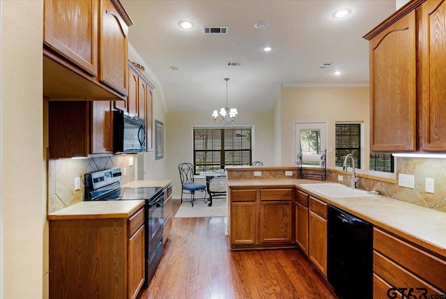 5609 Andover Dr, Tyler, TX 75707 - kitchen with visible vents, a sink, black appliances, a peninsula, and an inviting chandelier