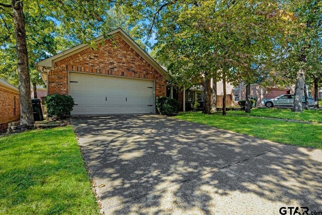 5609 Andover Dr, Tyler, TX 75707 - view of front facade with concrete driveway, brick siding, a front yard, and a garage