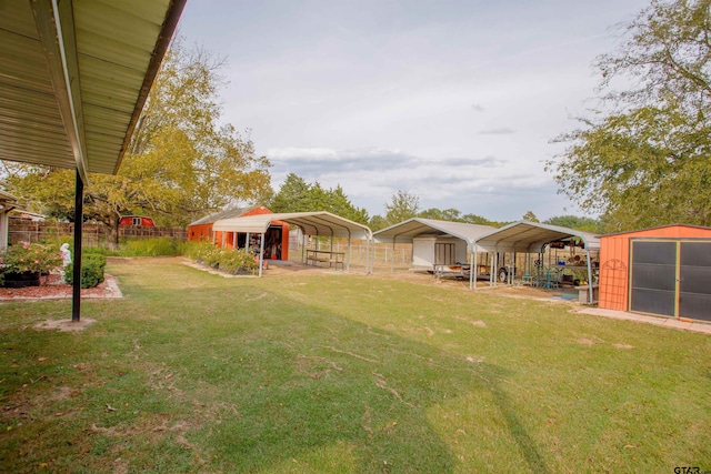 view of yard featuring a storage unit and a carport