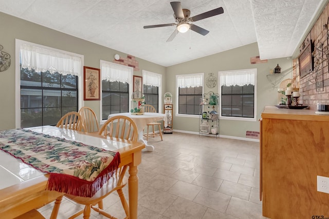 tiled dining area with vaulted ceiling, ceiling fan, and a textured ceiling