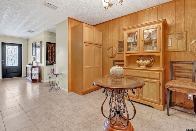 foyer with wood walls and a textured ceiling