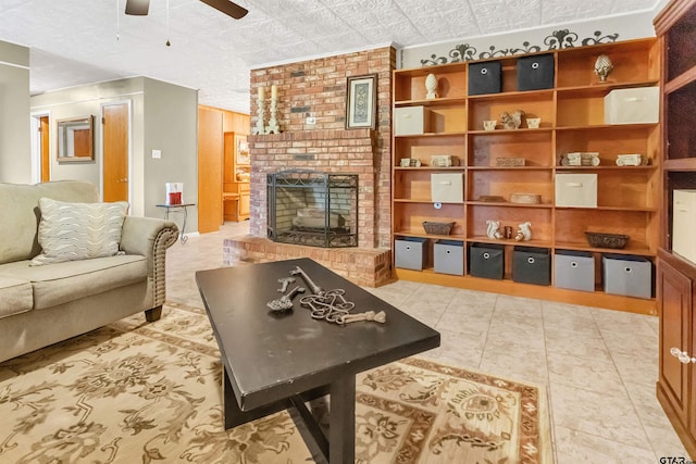 living room featuring a brick fireplace, ceiling fan, and light tile patterned floors