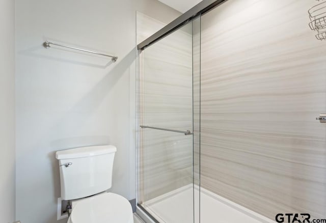bathroom featuring toilet and a stall shower