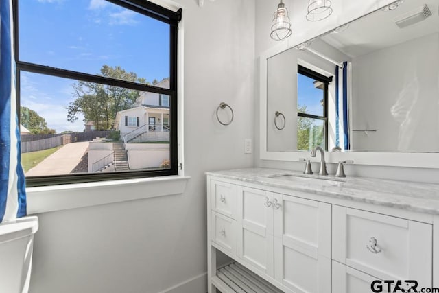 bathroom featuring baseboards, visible vents, vanity, and toilet