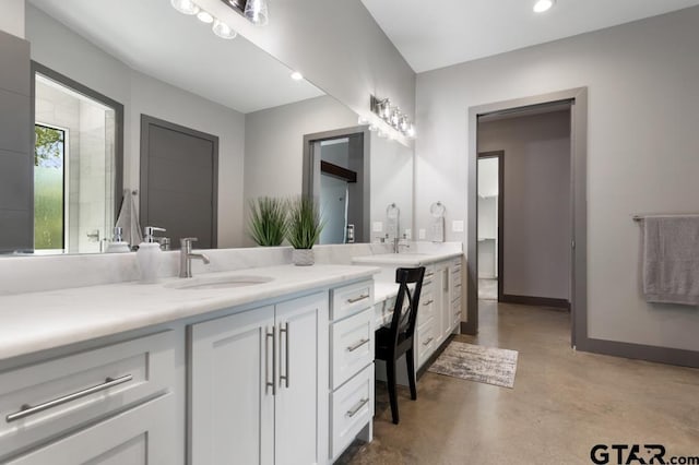 bathroom featuring concrete flooring, baseboards, vanity, and recessed lighting