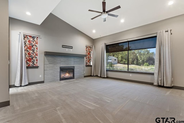 unfurnished living room with a ceiling fan, carpet floors, a fireplace, baseboards, and lofted ceiling