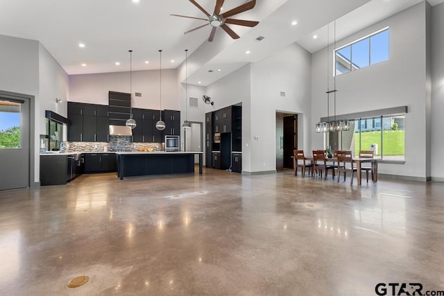kitchen with oven, ceiling fan, dark cabinets, light countertops, and high vaulted ceiling
