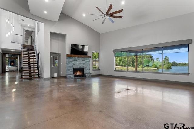 unfurnished living room featuring high vaulted ceiling, concrete flooring, ceiling fan, a fireplace, and baseboards