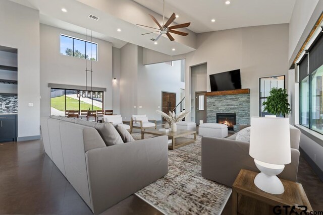living room featuring high vaulted ceiling, ceiling fan, a fireplace, visible vents, and recessed lighting