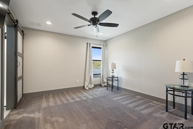 unfurnished room featuring a barn door, recessed lighting, carpet, baseboards, and ceiling fan