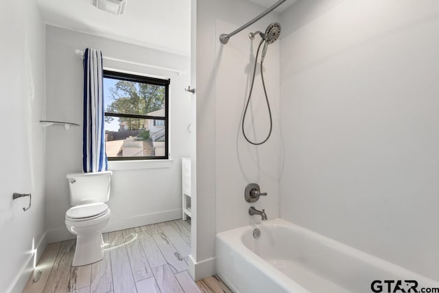 full bath featuring toilet, shower / bath combination, visible vents, and baseboards
