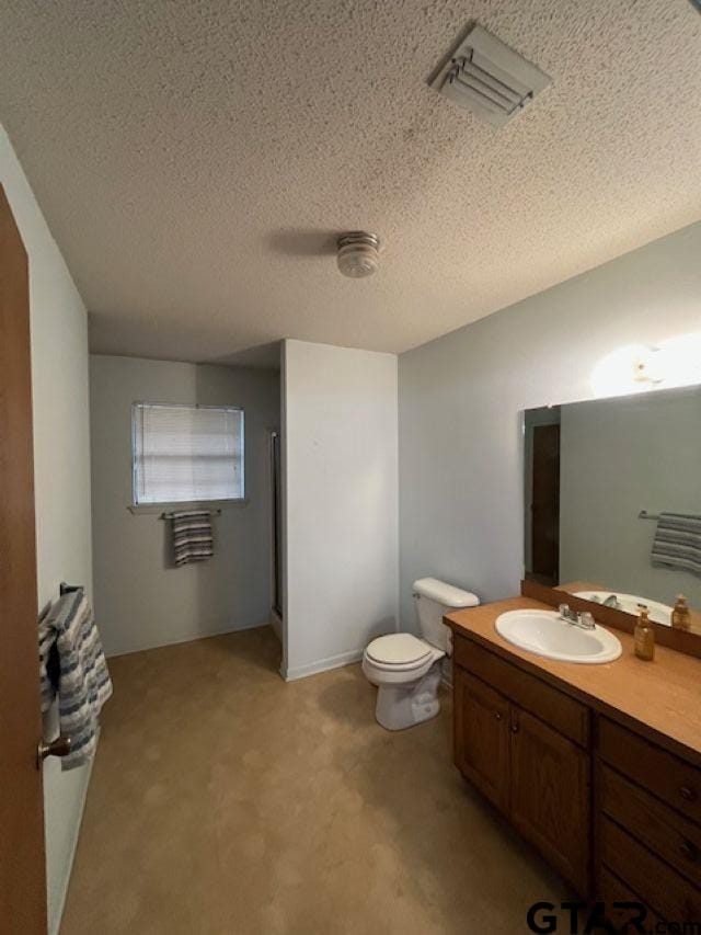 bathroom featuring visible vents, toilet, a textured ceiling, and vanity