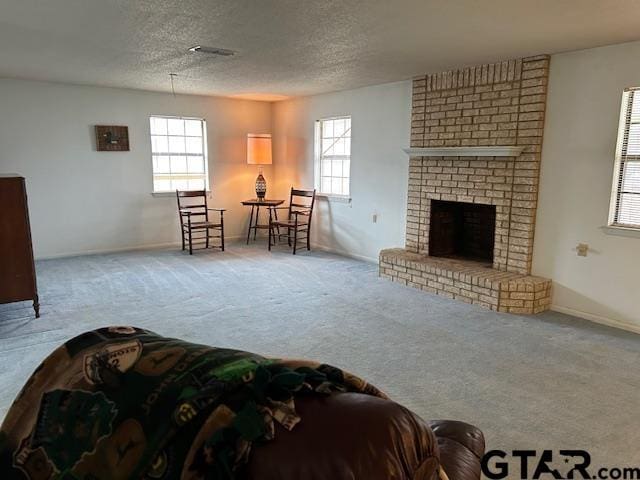 living room featuring baseboards, a textured ceiling, a brick fireplace, and carpet flooring