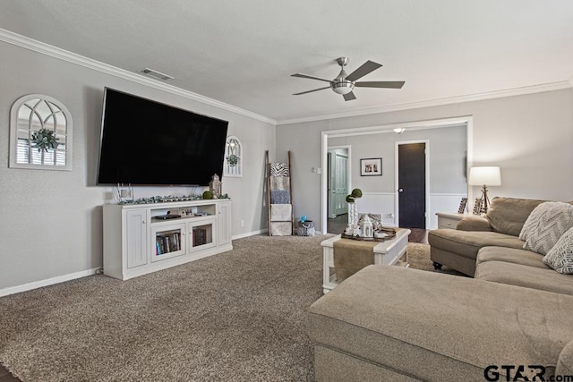 carpeted living area featuring ornamental molding, visible vents, and a ceiling fan