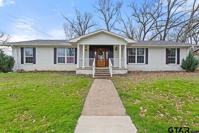 ranch-style house featuring brick siding, a porch, and a front yard