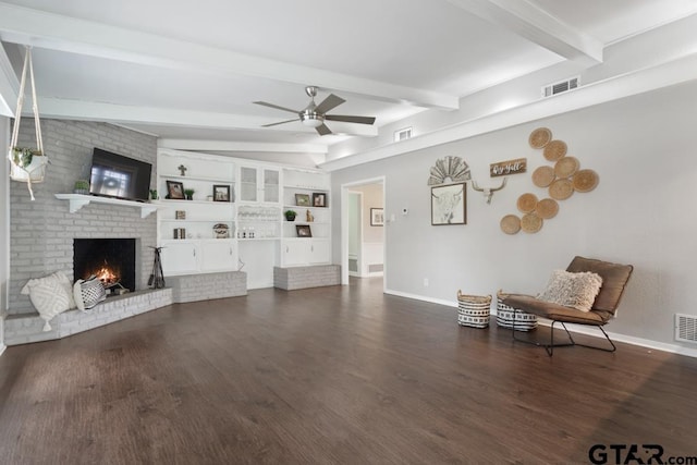 living room with a fireplace, visible vents, dark wood finished floors, and beam ceiling