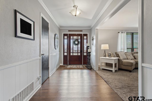 entrance foyer featuring a wainscoted wall, a healthy amount of sunlight, and wood finished floors