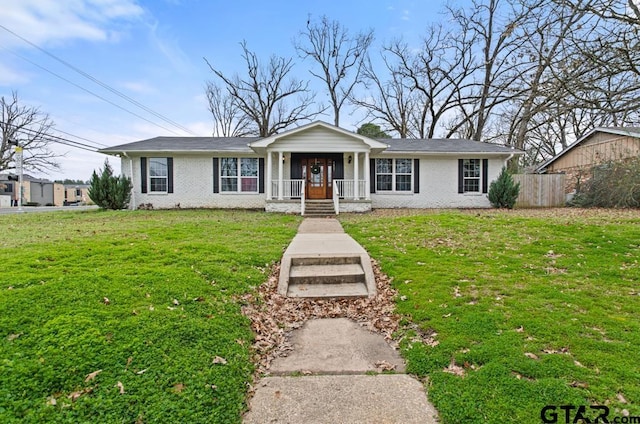 single story home featuring covered porch, brick siding, a front yard, and fence