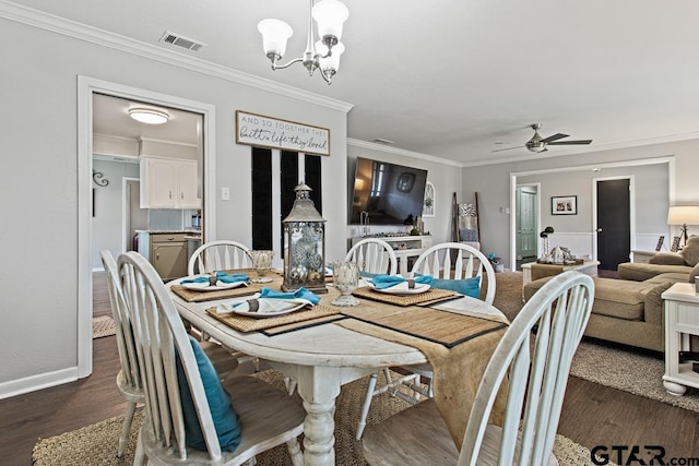 dining room with ceiling fan with notable chandelier, dark wood-style flooring, visible vents, and crown molding