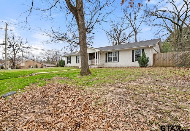 ranch-style home featuring fence, a front lawn, and brick siding