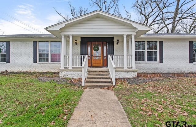 view of front of home featuring a porch and brick siding