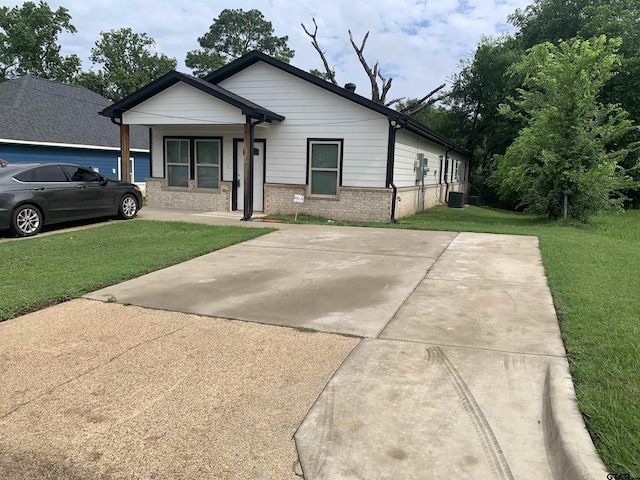 501 W Vance St, Tyler, TX 75702 - view of front of house featuring a front yard, brick siding, central AC, and covered porch