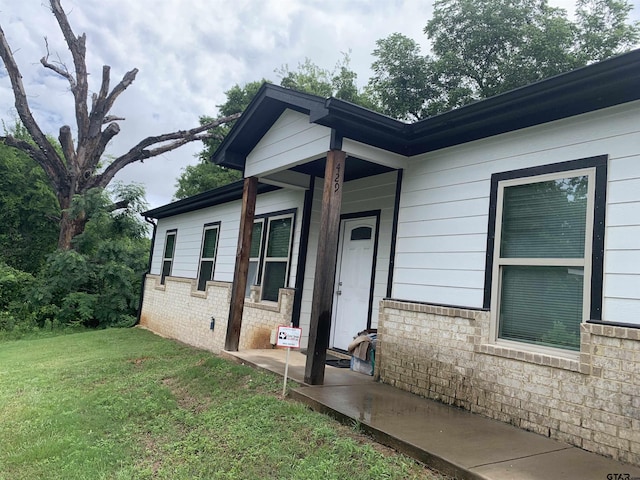 501 W Vance St, Tyler, TX 75702 - doorway to property featuring a lawn and brick siding