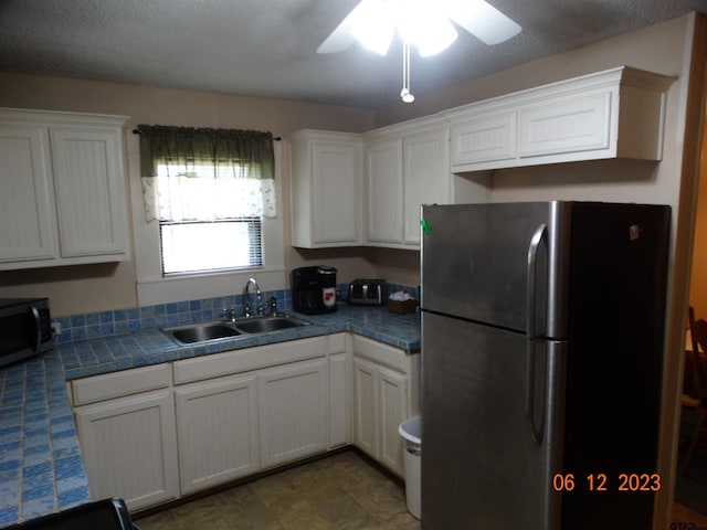 kitchen with white cabinetry, sink, ceiling fan, stainless steel appliances, and a textured ceiling