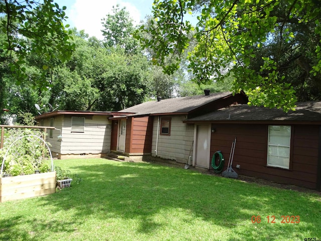 rear view of property featuring a yard