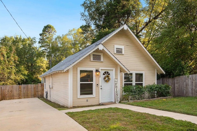 bungalow-style house featuring a front lawn and an outdoor structure