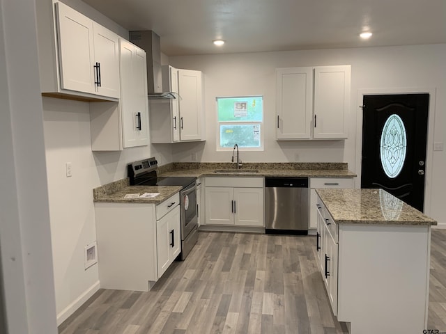 kitchen with sink, stainless steel appliances, light hardwood / wood-style flooring, stone countertops, and white cabinets