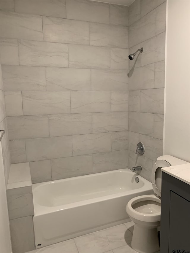 full bathroom featuring vanity, tiled shower / bath combo, and toilet