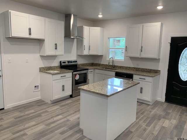 kitchen featuring sink, wall chimney exhaust hood, appliances with stainless steel finishes, a kitchen island, and white cabinetry